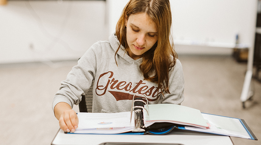 student sitting at a desk looking at a diagram of a brain in a workbook