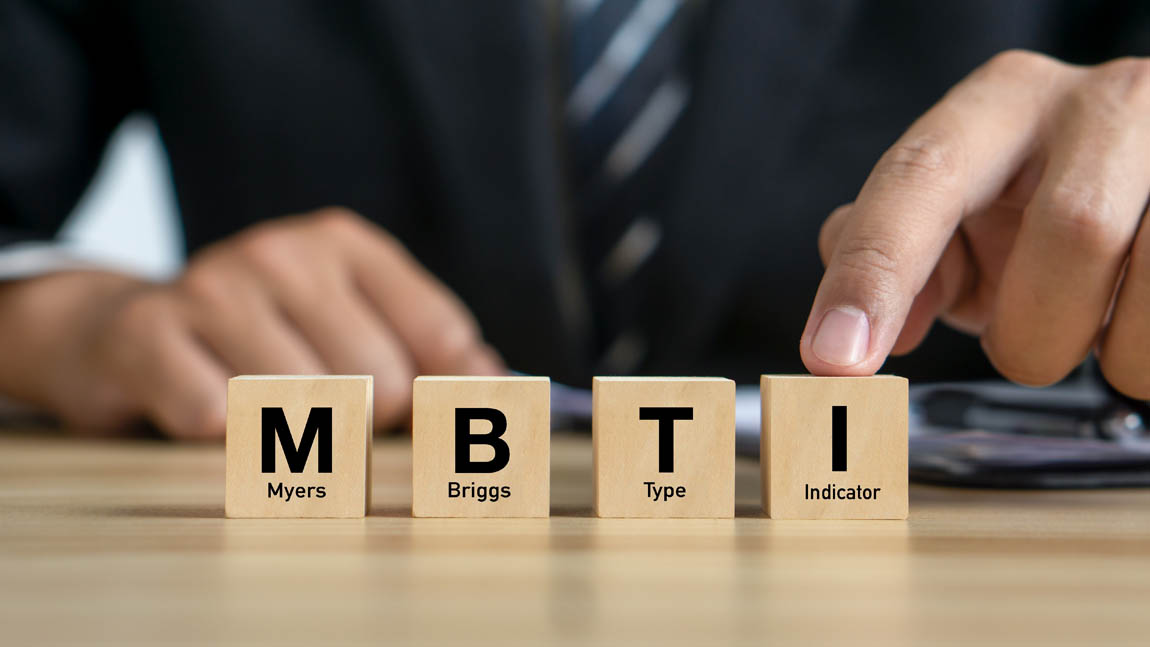 MBTI,Myers-Briggs Type Indicator.Psychological and personality test concept.Businessman and MBTI word on wood cubes.
